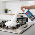 Kitchen bubble cleaner spray being used on greasy stove burner with foam bubbles