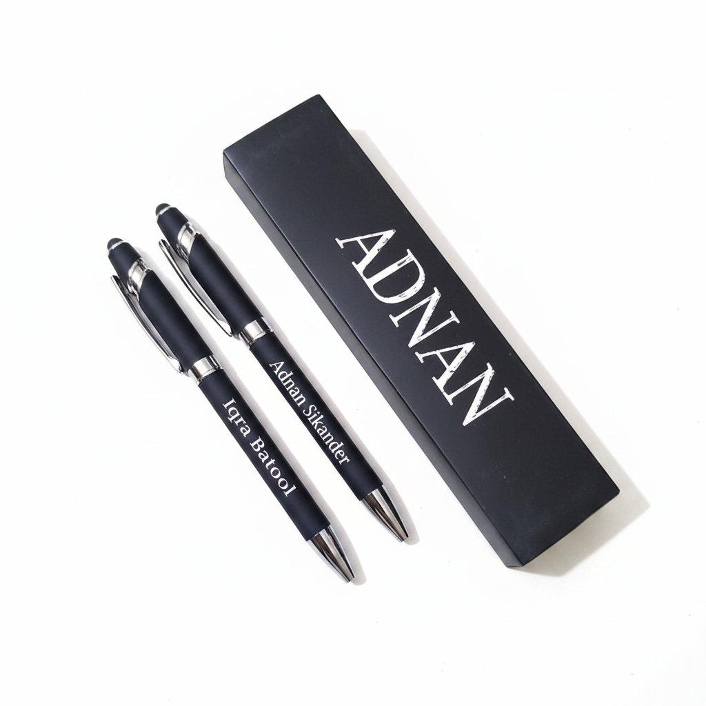Two matte black personalized engraved pens with black gift box flat lay white background