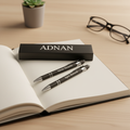 Matte black personalized engraved metal pen on notebook beside black gift box lifestyle photo