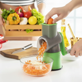 Green grey manual rotary drum grater grating carrots and cheese on kitchen counter lifestyle photo